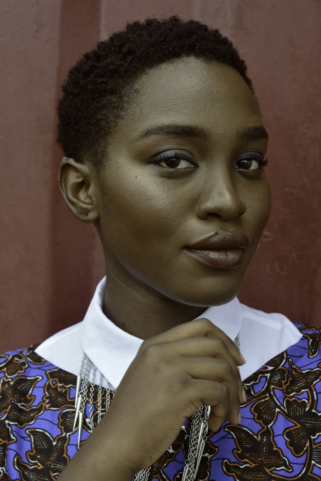 A woman with short hair in a patterned top and white collar
